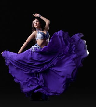 Brunette young woman dancing oriental dance Isolated on black