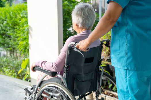 Caregiver help and care Asian senior or elderly old lady woman patient sitting in wheelchair on ramp at nursing hospital, healthy strong medical concept