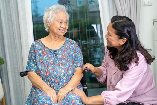 Help and care Asian senior or elderly old lady woman patient sitting on wheelchair at nursing hospital ward, healthy strong medical concept