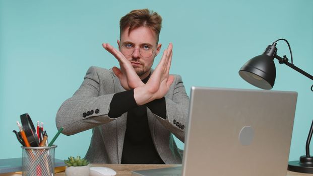 Stop, enought. Business man at office say No hold palm folded crossed hands in stop gesture, warning of finish, prohibited access, declining communication, body language, danger on blue background