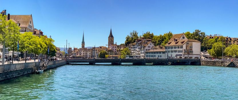 View from the Muehlsteg on the Limmatquai, the Rudolf Brun Bridge and the Churches of St. Peter and Fraumuenster in Zurich, Switzerland