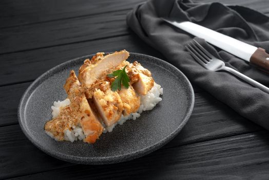 Indian chicken with butter and basmati rice in a plate. Black background. Place for text. Chicken in oil, a traditional Indian dish. Top view. Chicken tikka masala. Indian Cuisine.