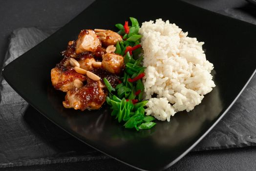 Kung Pao chicken with gravy. Asian food on a black background