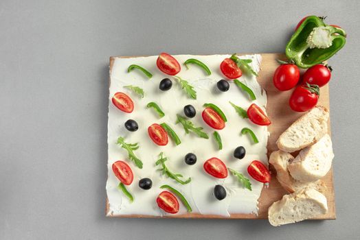 A board of butter or cream cheese on a wooden board. Appetizer. Top view. Butter board food trend, cracker with butter.