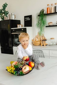 A child picks his nose in the kitchen.