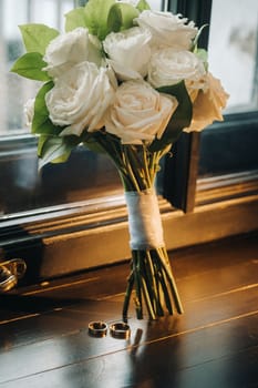 The bride's wedding bouquet of fresh pink flowers and wedding rings. Wedding Details.