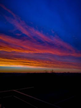 Beautiful colorful morning sunrise full of clouds seen from balcony with long metal railings