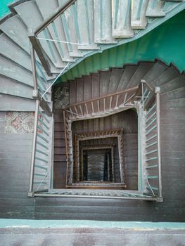 Interior of old renovated wooden square spiral staircase