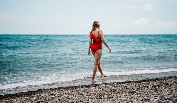 Young happy woman walks carefree on the seaside . Portrait beautiful young woman relax smile around beach sea ocean in holiday vacation travel trip