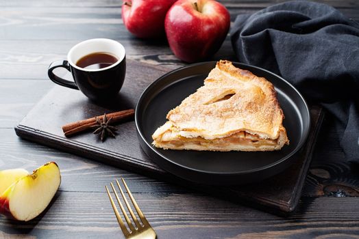 Autumn food. Homemade piece of apple pie with fresh red apples on black table