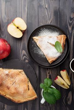 Autumn food. Homemade apple pie with slice with fresh red apples on wooden table