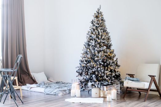 Merry Christmas and Happy New Year. Christmas tree with presents and lights in light and airy living room next to the window