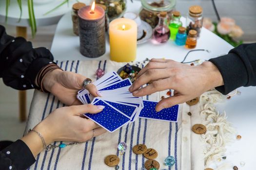 A woman fortuneteller tells a man on tarot cards. Selective focus. People.