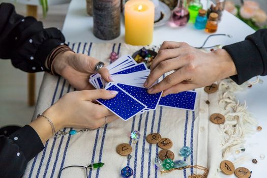 A woman fortuneteller tells a man on tarot cards. Selective focus. People.