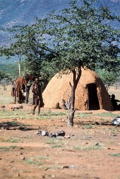 May 15, 2005.Himba village. unidentified Himba women with the traditional hairstyle, necklace and the typical ochre tinted skin. Epupa Falls, Kaokoland or Kunene Province, Namibia, Africa