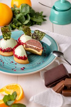 Tempting sweet and sour dessert with chocolate mousse and orange confit in shortbread tartlet covered with glossy sugar glaze decorated with fragile caramel shards