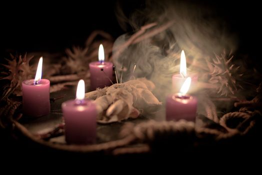 Pentagram amulet and black candle in autumn forest, natural background. Magic esoteric witches ritual. Mysticism, divination, wicca, occultism, witchcraft concept. Samhain sabbat