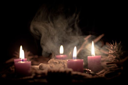 Voodoo doll, black candles, pentagram and old books on witch table. Occult, esoteric, divination and wicca concept. Mystic, voodoo and vintage background