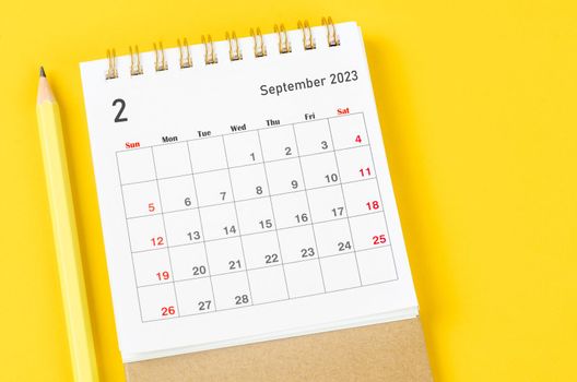 February 2023 Monthly desk calendar for 2023 with pencil on yellow background.