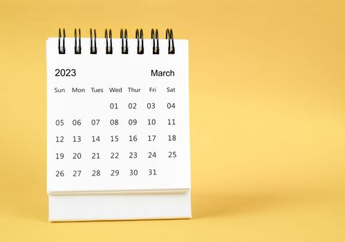March 2023 desk calendar on yellow color background.