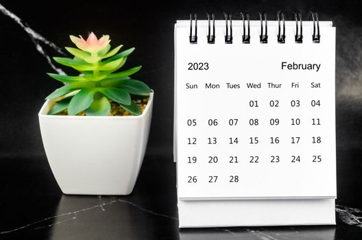 February 2023 Monthly desk calendar for 2023 year on black marble background.