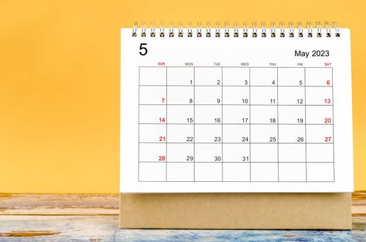 May 2023 Monthly desk calendar for 2023 year on yellow background.