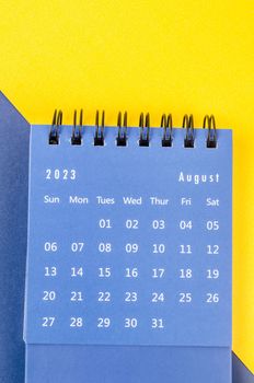 August 2023 Monthly desk calendar for 2023 year on blue and yellow background.