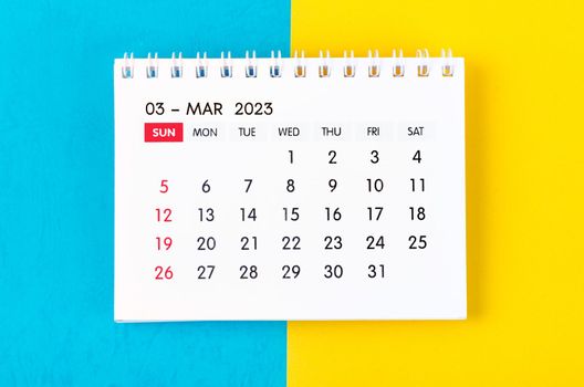 March 2023 Monthly desk calendar for 2023 year on blue and yellow background.