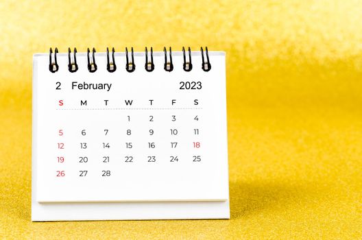February 2023 Monthly desk calendar for 2023 year on golden color background.