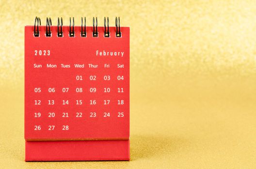 Red February 2023 Monthly desk calendar for 2023 year on golden color background.