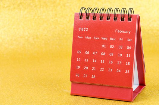 Red February 2023 Monthly desk calendar for 2023 year on golden color background.