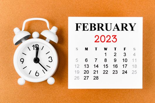 February 2023 Monthly calendar for the organizer to plan 2023 year with alarm clock on yellow background.