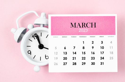 March 2023 Monthly calendar year with alarm clock on pink colour background.