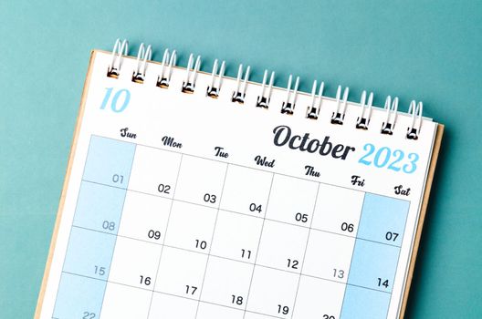 October 2023 calendar desk for the organizer to plan and reminder isolated on blue background.