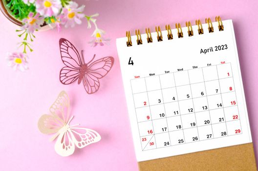 April 2023 desk calendar for the organizer to plan and reminder and paer butterfly on pink colour background.