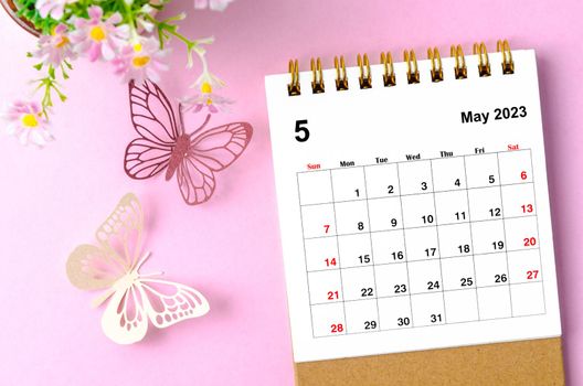 May 2023 desk calendar for the organizer to plan and reminder and paer butterfly on pink colour background.