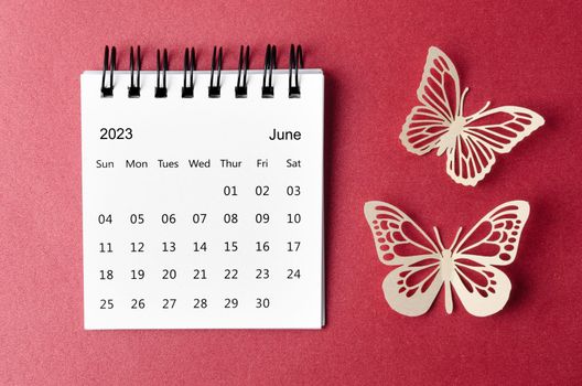 June 2023 desk calendar for the organizer to plan and reminder with paer butterfly on red background.