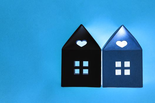 Home model with light at night time on blue colour background with empty space for your text or message