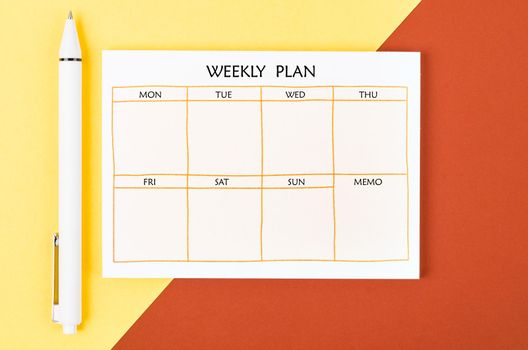 Blank weekly plan notice block on beautiful background. Empty schedule and a pen.