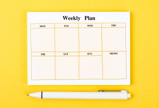 Blank weekly plan notice block on yellow background. Empty schedule and a pen.