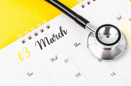 Stethoscope medical and March 2023 desk calendar on the red background, schedule to check up healthy concepts.