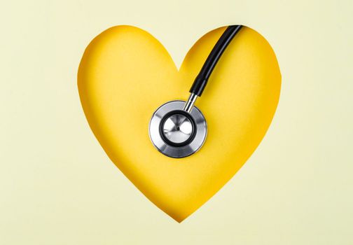 Healthcare Stethoscope Medical on Yellow Background with Paper Heart Shape.