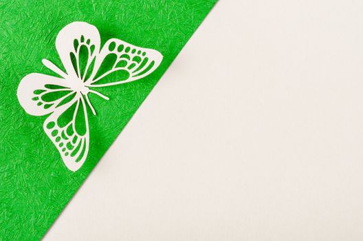 Butterfly made from carve paper or cutting on green and yellow background with empty space for your text or message.