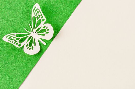 A Butterfly made from carve paper or cutting on green and yellow background with empty space for your text or message.