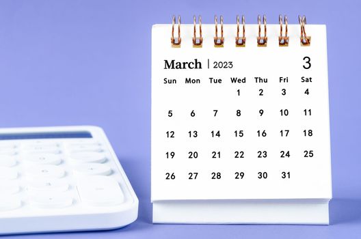 March 2023 Monthly desk calendar for 2023 year with calculator on purple background.