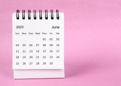 June 2023 desk calendar on pink color background.