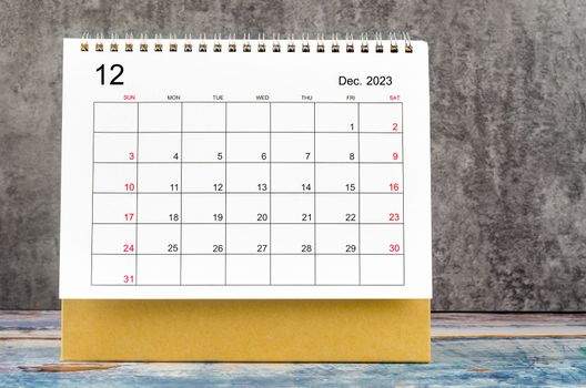 December 2023 Monthly desk calendar for 2023 year on wooden table.