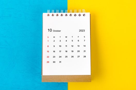 October 2023 Monthly desk calendar for 2023 year on blue and yellow background.