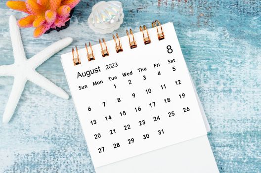 August 2023 Monthly desk calendar for 2023 year on old blue wooden background.