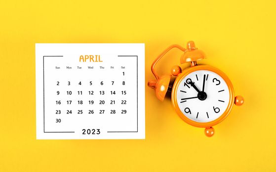 April 2023 Monthly calendar for 2023 year with alarm clock on yellow background.